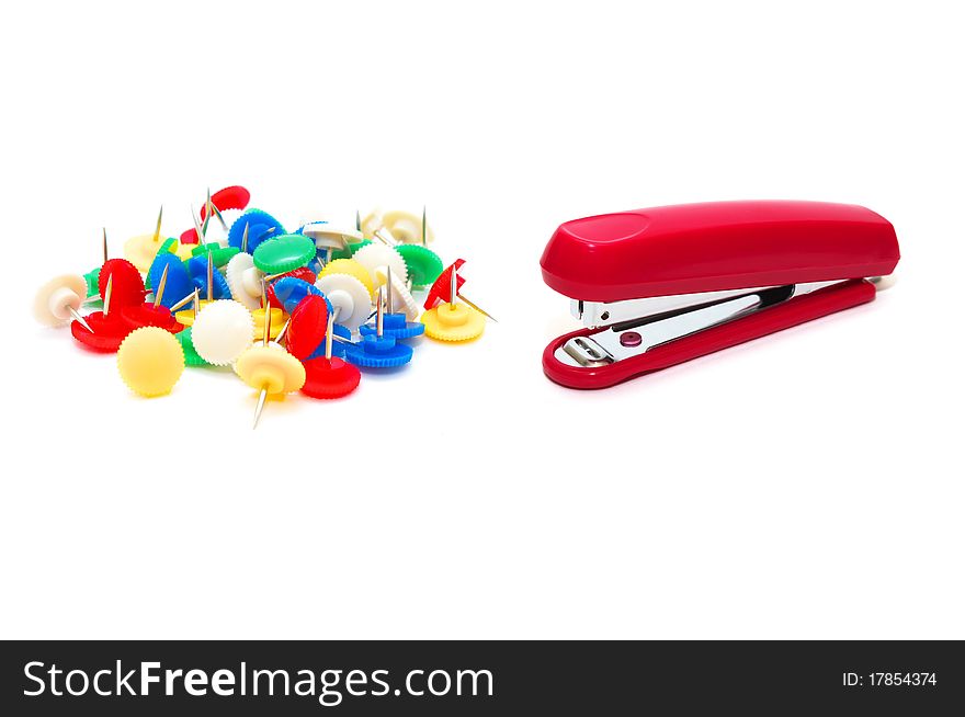 Photo of the red stapler with colour drawing pins on white background