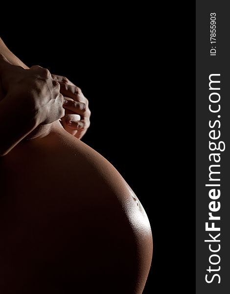 Pregnant abdomen on black background