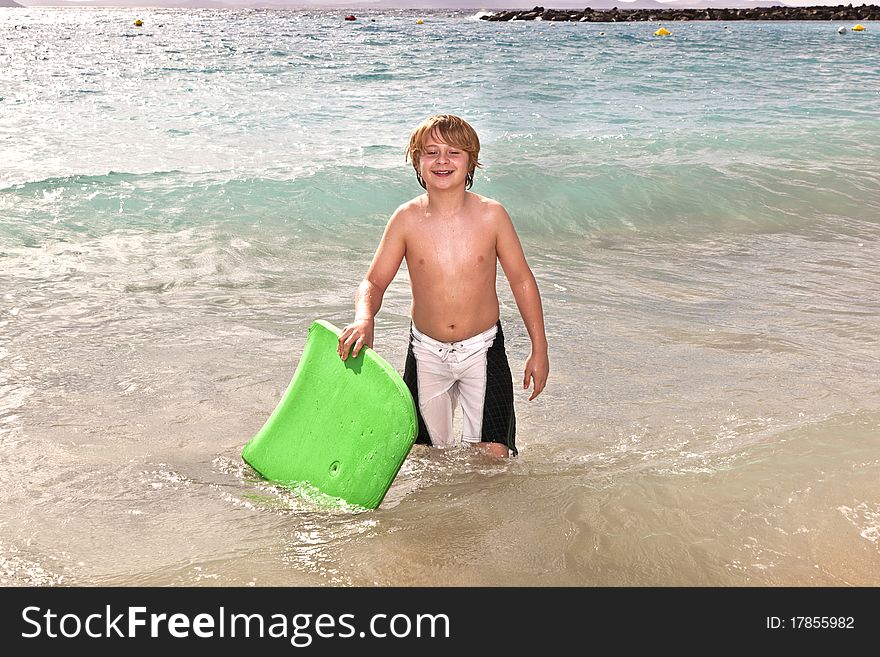 Boy has fun with the surfboard at the beach. Boy has fun with the surfboard at the beach