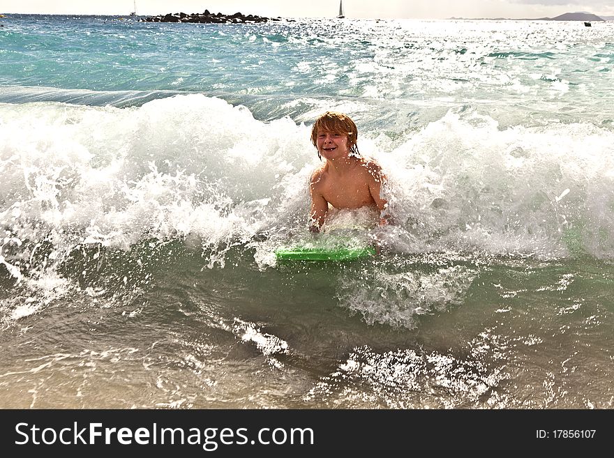 Boy has fun with the surfboard at the beach. Boy has fun with the surfboard at the beach