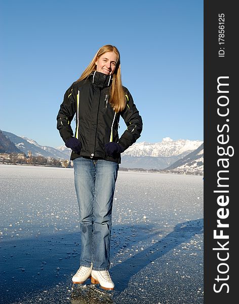 Young woman ice skating on frozen lake on a sunny day