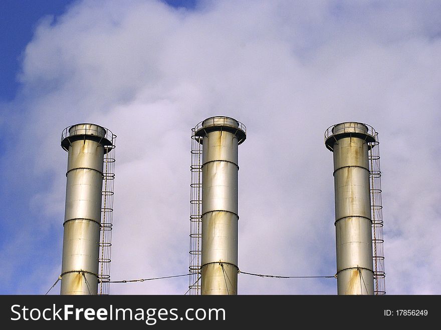 Inactive power plant towers on cloudy summer day.