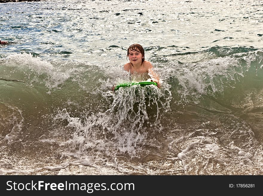 Boy has fun with the surfboard at the beach. Boy has fun with the surfboard at the beach
