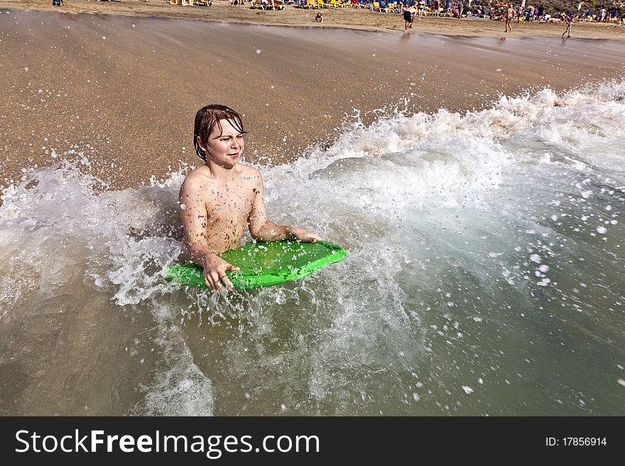 Boy has fun with the surfboard at the beach. Boy has fun with the surfboard at the beach