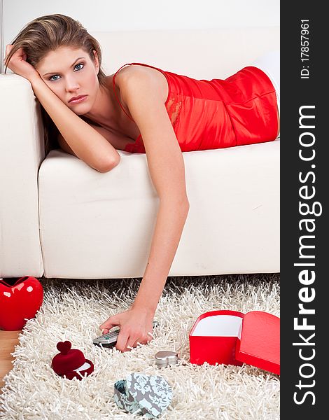 Laying, sorrowful girl holding a remote control. Laying, sorrowful girl holding a remote control