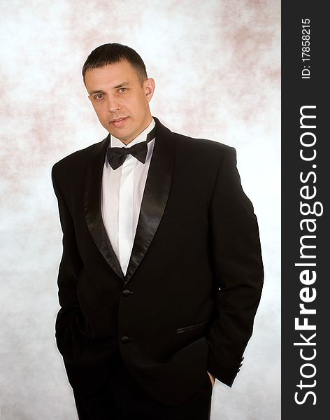 Portrait the man in a classical tuxedo on an abstract background