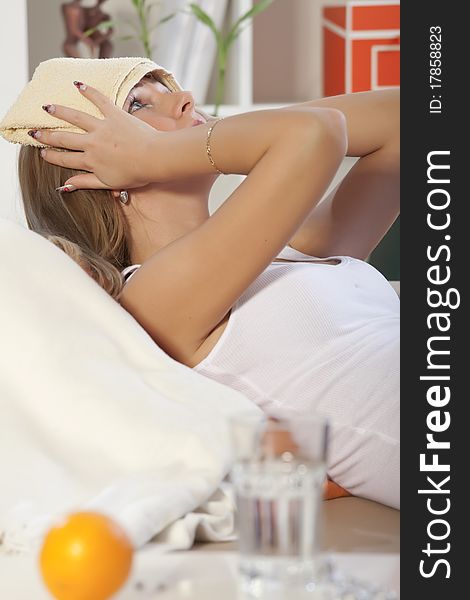 Woman with headache lying in bed at home