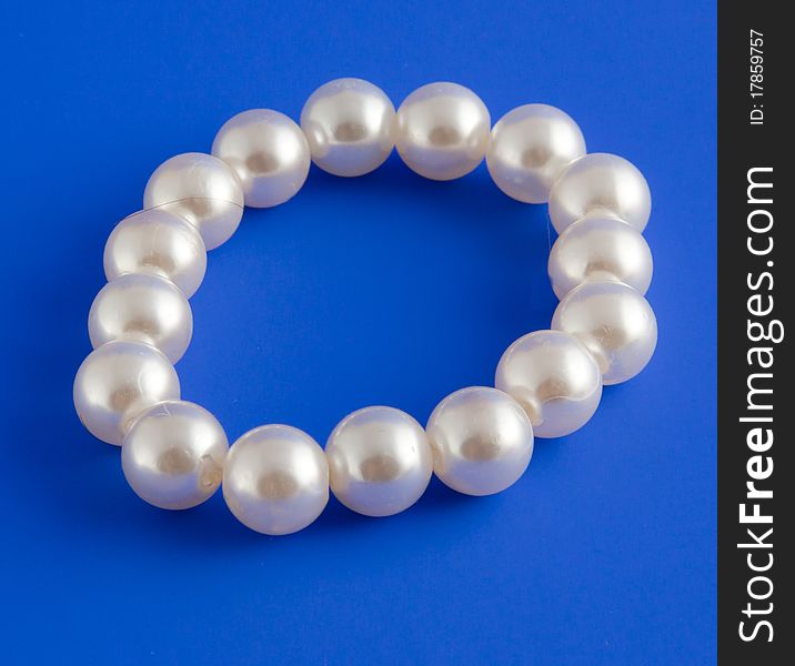 White isolated beads over blue background. Image. White isolated beads over blue background. Image.