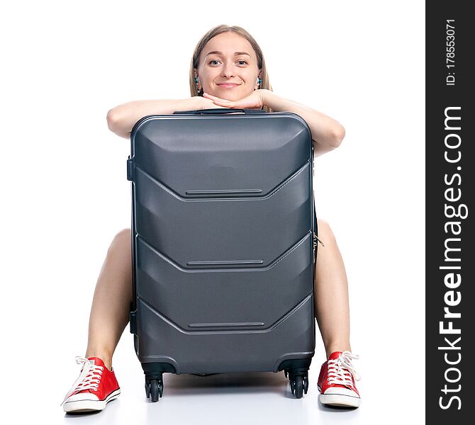 Woman with travel suitcase sitting waiting smiling on white background isolation