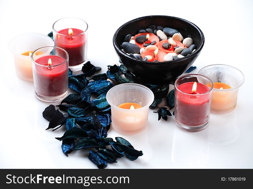 Candles, blue potpourri and a black bowl on a white background. Candles, blue potpourri and a black bowl on a white background