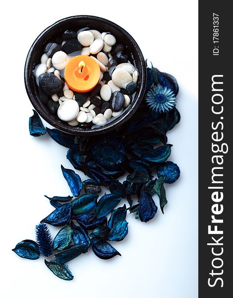 Orange candle in a black bowl and blue potpourri. Orange candle in a black bowl and blue potpourri