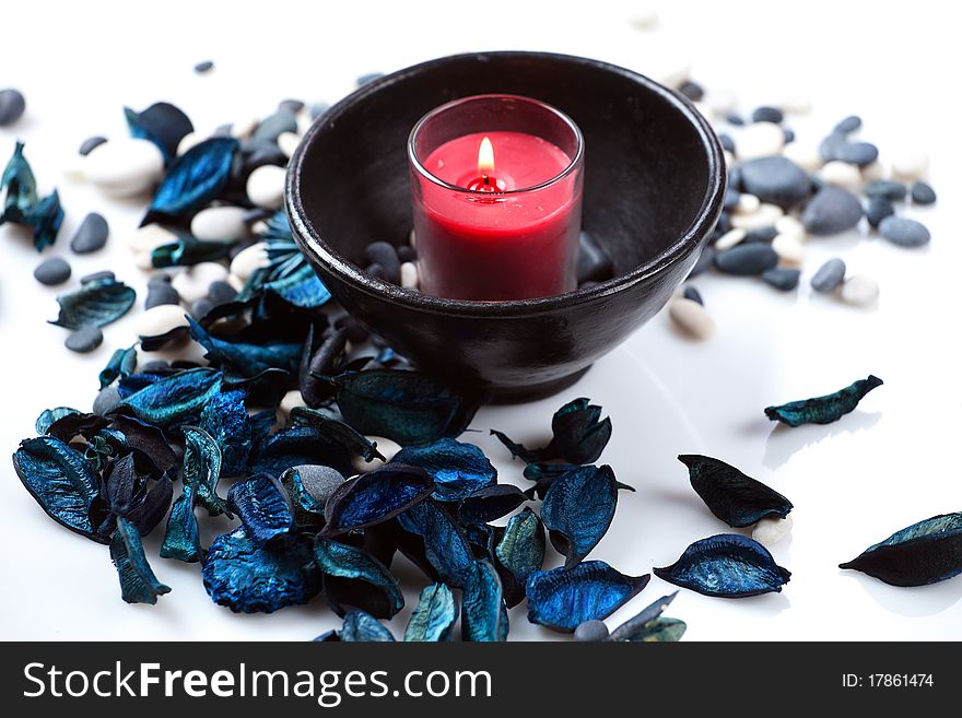 Red candle in a black bowl and a blue potpourri. Red candle in a black bowl and a blue potpourri