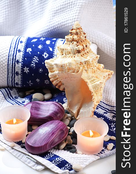 Seashell, candles and a soap placed on a towel. Seashell, candles and a soap placed on a towel