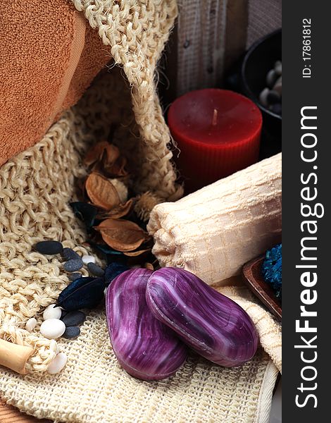 Two violet soaps and the red candle placed among towels. Two violet soaps and the red candle placed among towels