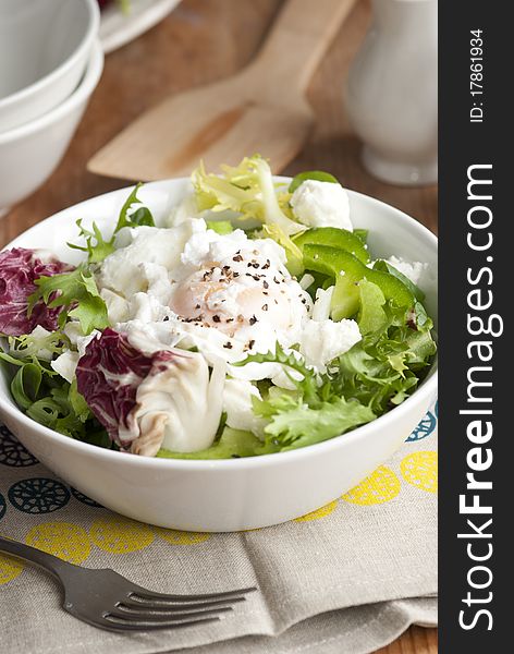 Leaf salad with feta cheese and poached egg