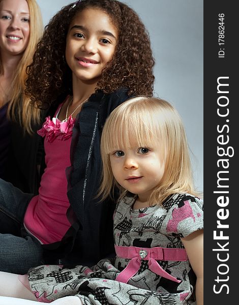 Young girl in front with her older sister behind and their mother in the back. Generational as well as a contrast between the different skin tones. Young girl in front with her older sister behind and their mother in the back. Generational as well as a contrast between the different skin tones.