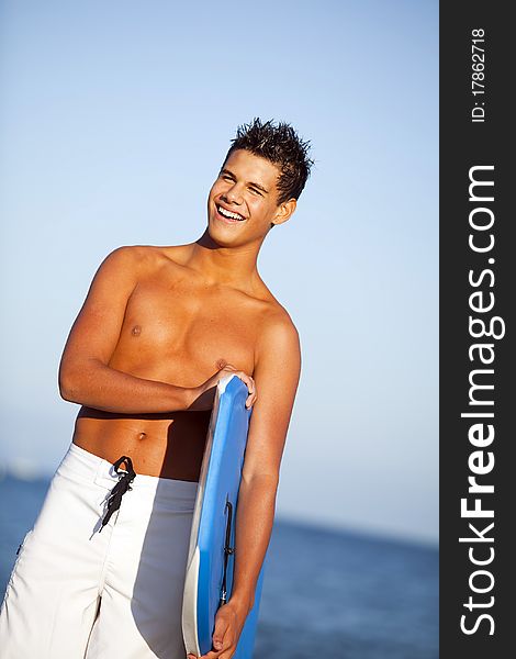 Young man at the beach with a boogie board. Young man at the beach with a boogie board