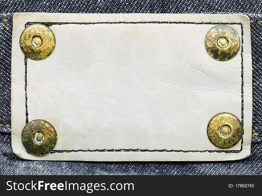 Frame for your text - closeup of blank white grungy artificial leather label with yellow metal rivets. Frame for your text - closeup of blank white grungy artificial leather label with yellow metal rivets