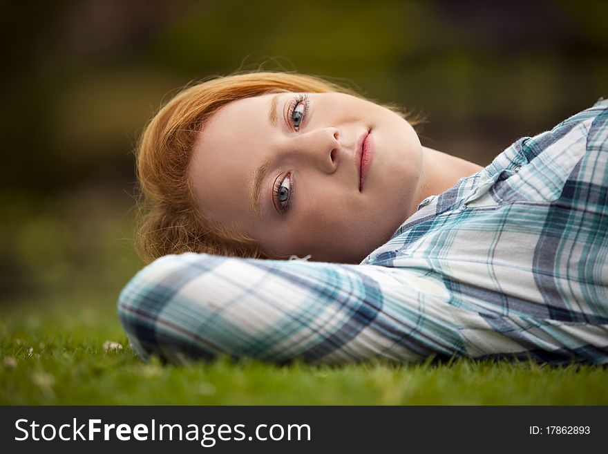 Young woman relaxing outside in the grass