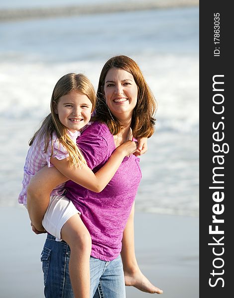 Loving mother and daughter playing on the beach