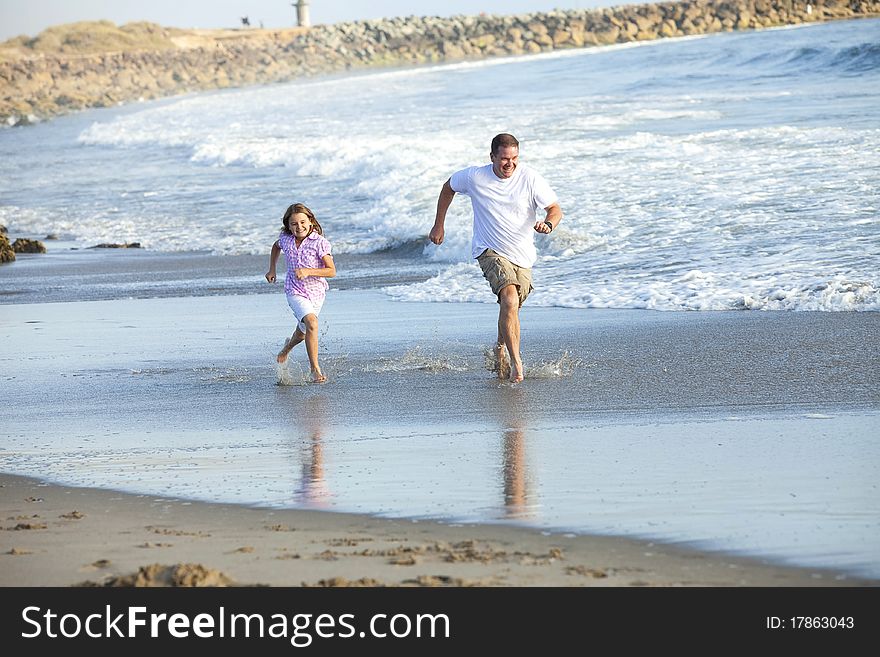 Father and daughter running at the beach