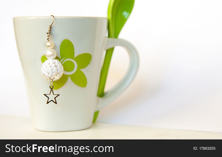 White crocheted earring on white cup