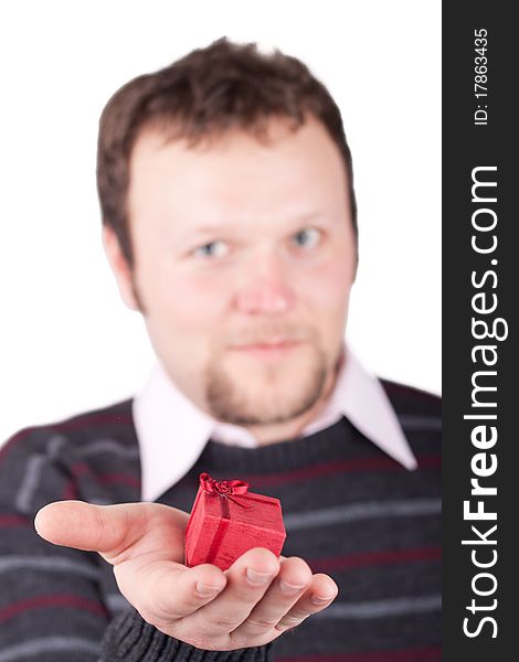 Young man holding valentine gift in his hand. He is giving it somebody. Isolated on white.