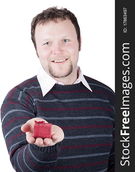 Young man holding valentine gift in his hand. He is giving it somebody. Isolated on white.