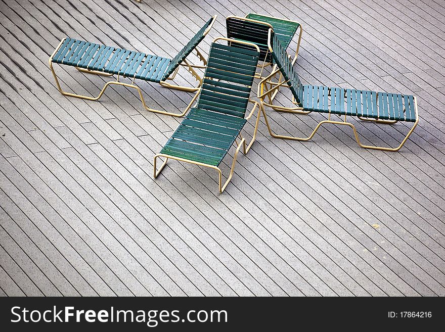 Four back to back lounge chairs on a deck. Four back to back lounge chairs on a deck