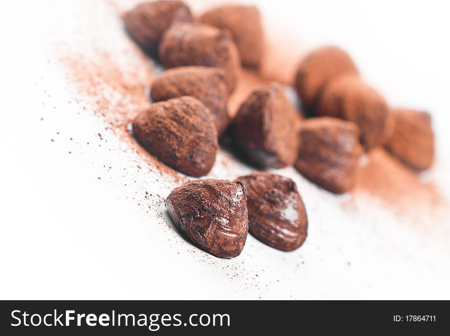 Chocolate truffles, sprinkled with cocoa, white background
