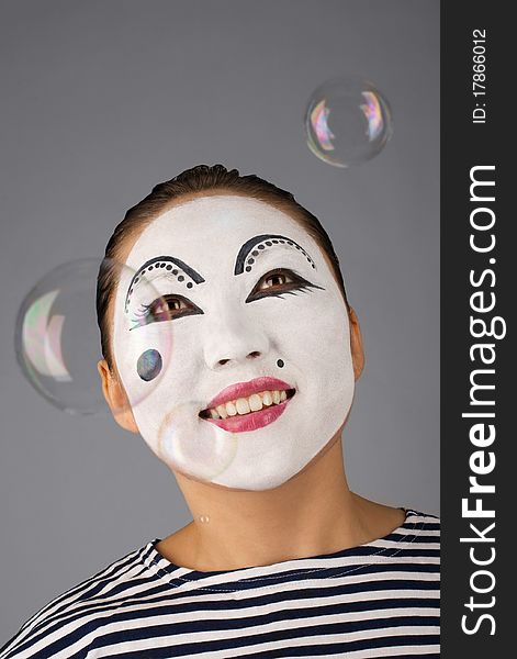 Smiling mime portrait with bubbles on grey background. Smiling mime portrait with bubbles on grey background