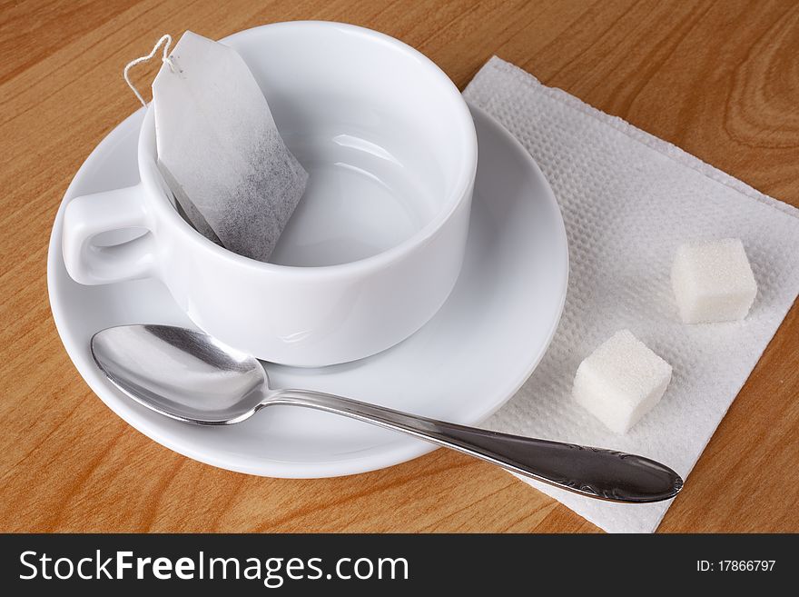 Cup for tea, sugar and spoon on table