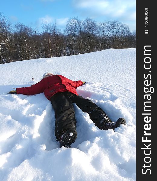 Winter holidays. The boy lay on the snow