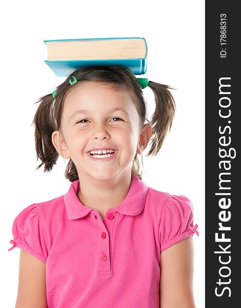 Happy smiling little girl carrying a book on her head isolated on white background. Happy smiling little girl carrying a book on her head isolated on white background