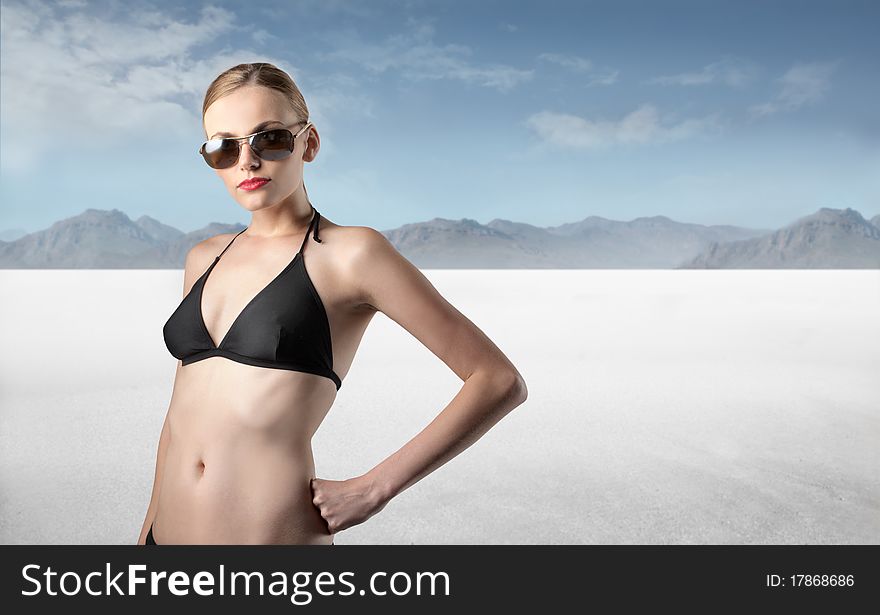 Beautiful woman wearing a swimsuit with desert on the background. Beautiful woman wearing a swimsuit with desert on the background