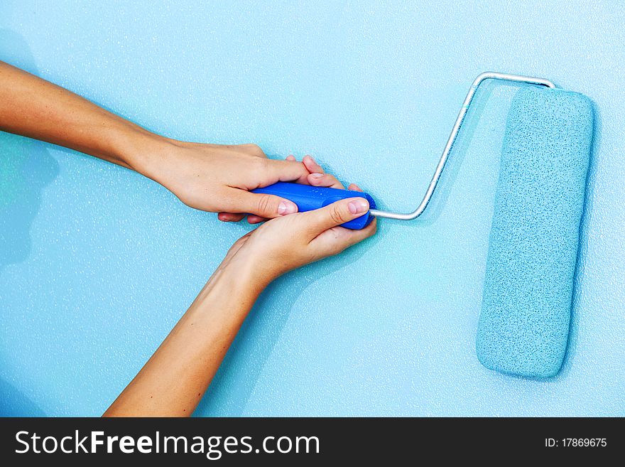 Woman paints the wall roller. Woman paints the wall roller