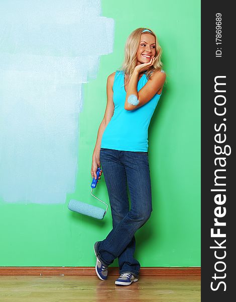 Woman paints the wall roller. Woman paints the wall roller