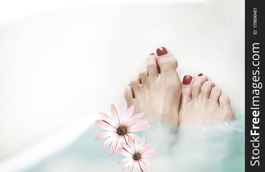 A woman performs Spa treatments for her feet with copy space. A woman performs Spa treatments for her feet with copy space