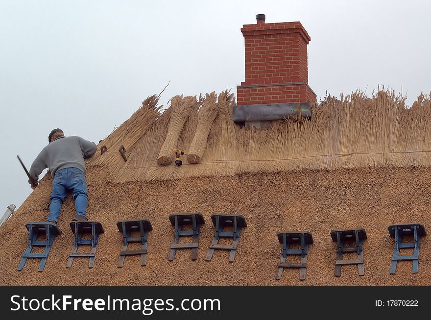 Traditional roof thatcher at work. Traditional roof thatcher at work