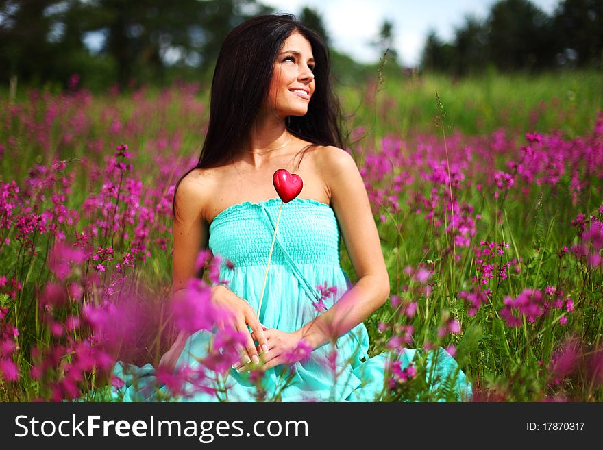 Woman on flower field heart in hands