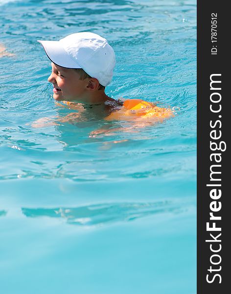 The boy floats in pool in summer