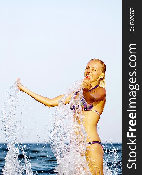 Happy young woman in sea with open hands.