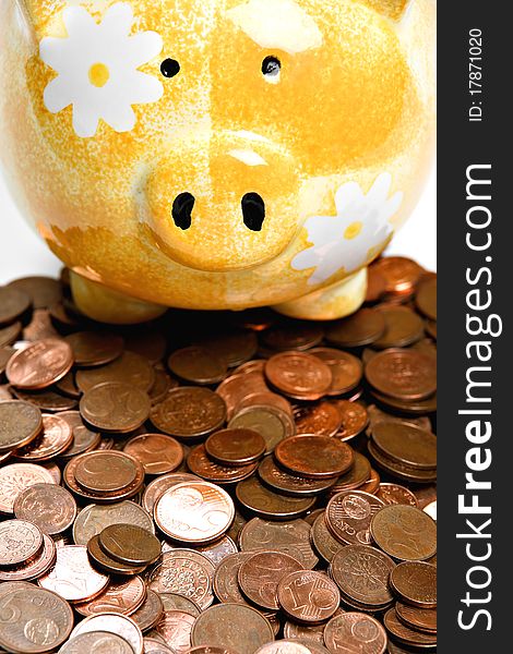 Yellow Ceramic Piggy Bank On A Pile Of Cents