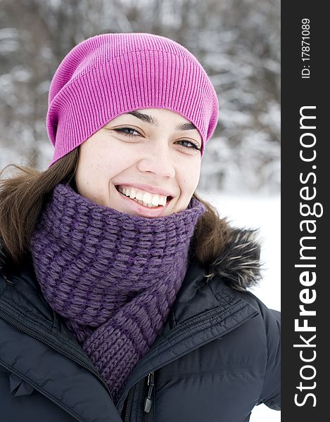 The young happy woman the brunette in a pink cap in winter