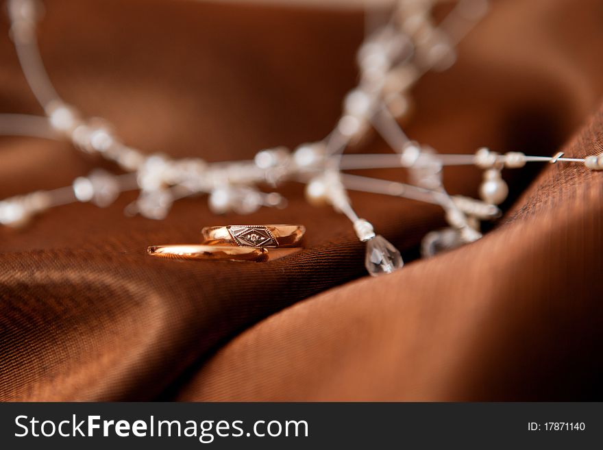 Two wedding rings and pearl collar on the cloth