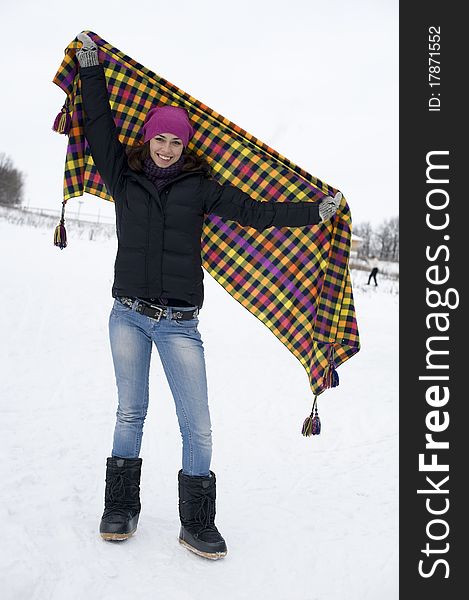 The young happy woman the brunette with a checkered plaid in hands