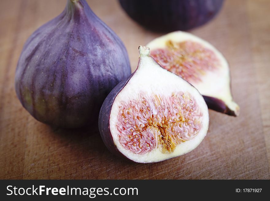 Four fresh figs on the wooden background