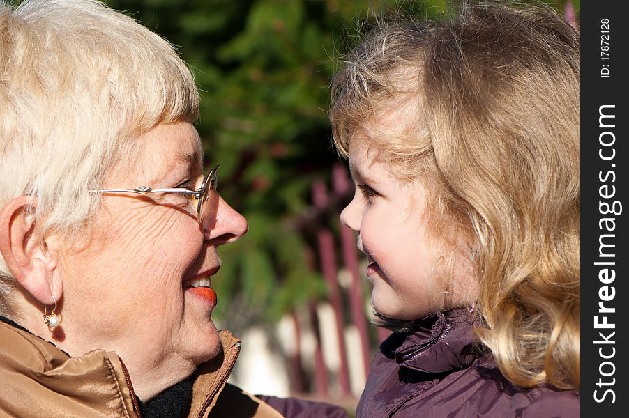 Happy grandmather and granddaughter in park