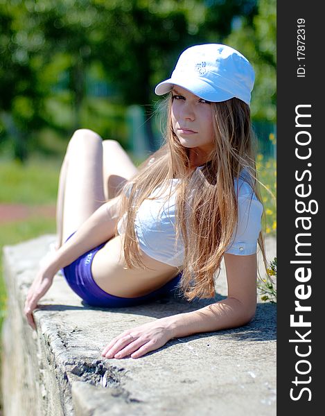 Beautiful girl on a tennis court on a background dark blue sky. Beautiful girl on a tennis court on a background dark blue sky