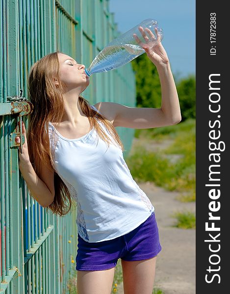 Beautiful girl on a tennis court on a background dark blue sky. Beautiful girl on a tennis court on a background dark blue sky